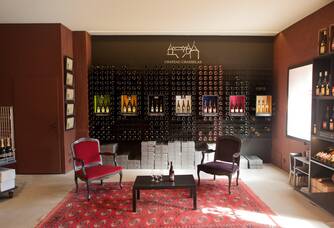 salle de dégustation, mur de bouteilles, deux fauteuils colorés