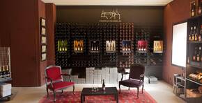 salle de dégustation, mur de bouteilles, deux fauteuils colorés